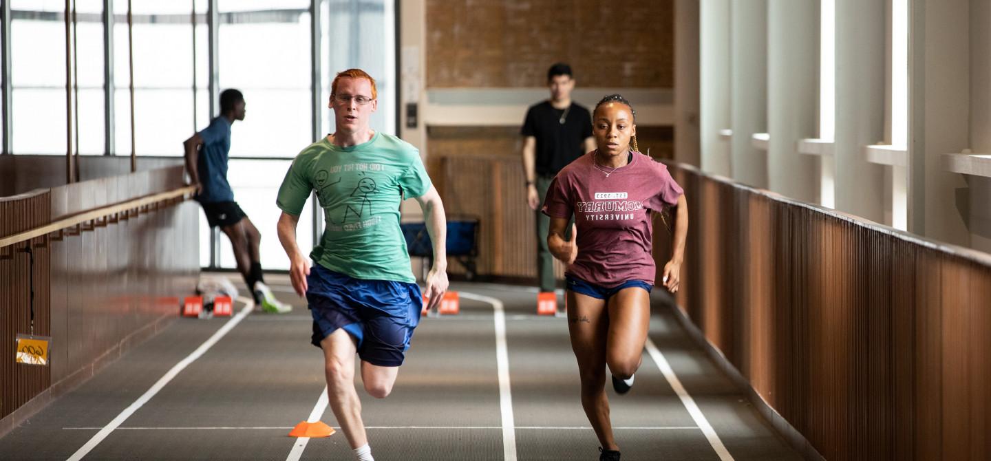 Two students run down the track at the Powerhouse in an race.