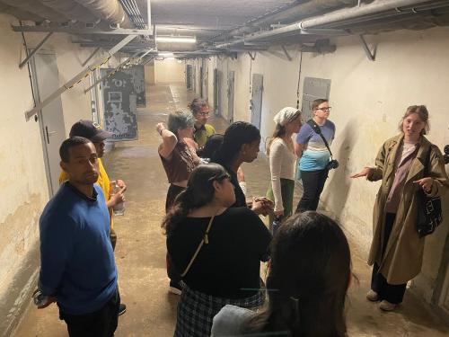 Students listening to a tour guide in a cell block at the Berlin-Hohensch