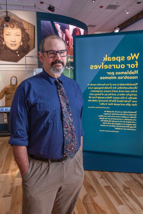 Tom Skwerski'87 stands at the entrance of the Native Truths exhibit.